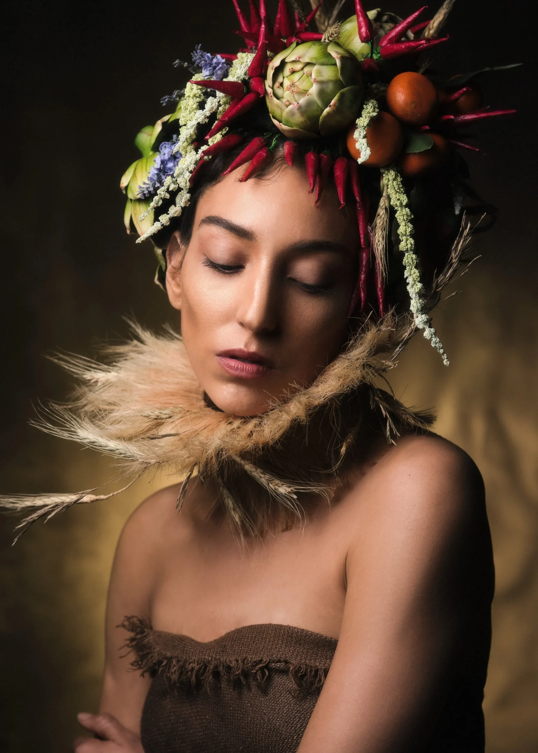 Conceptual fine art portrait of a woman adorned with fruit and vegetables