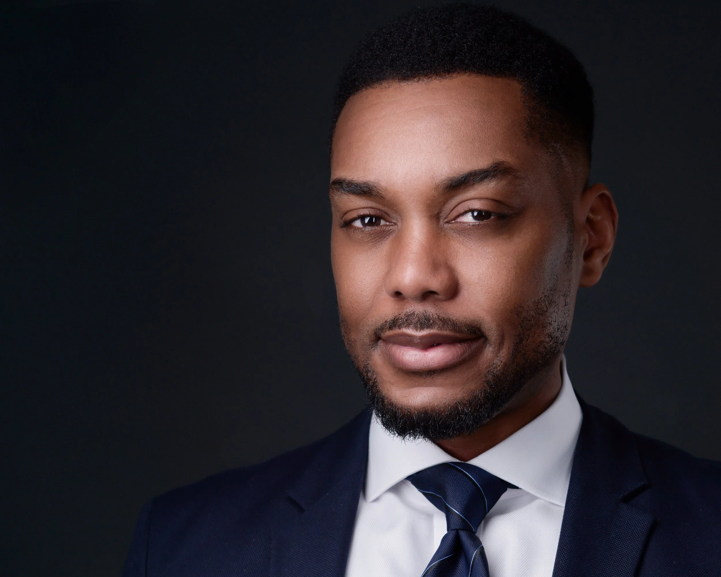 Professional headshot of a man in business casual attire