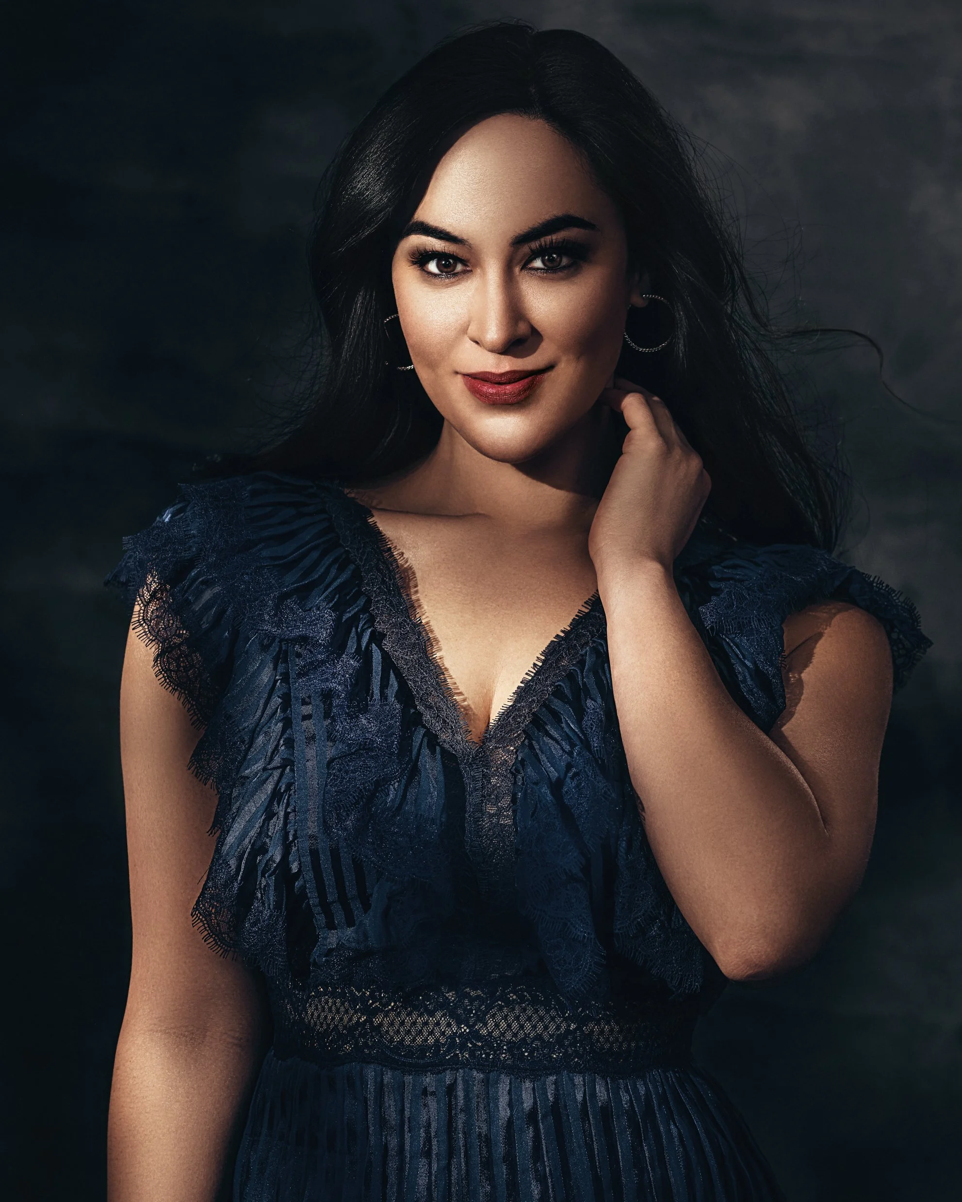 Elegant studio portrait of a woman in a navy evening dress