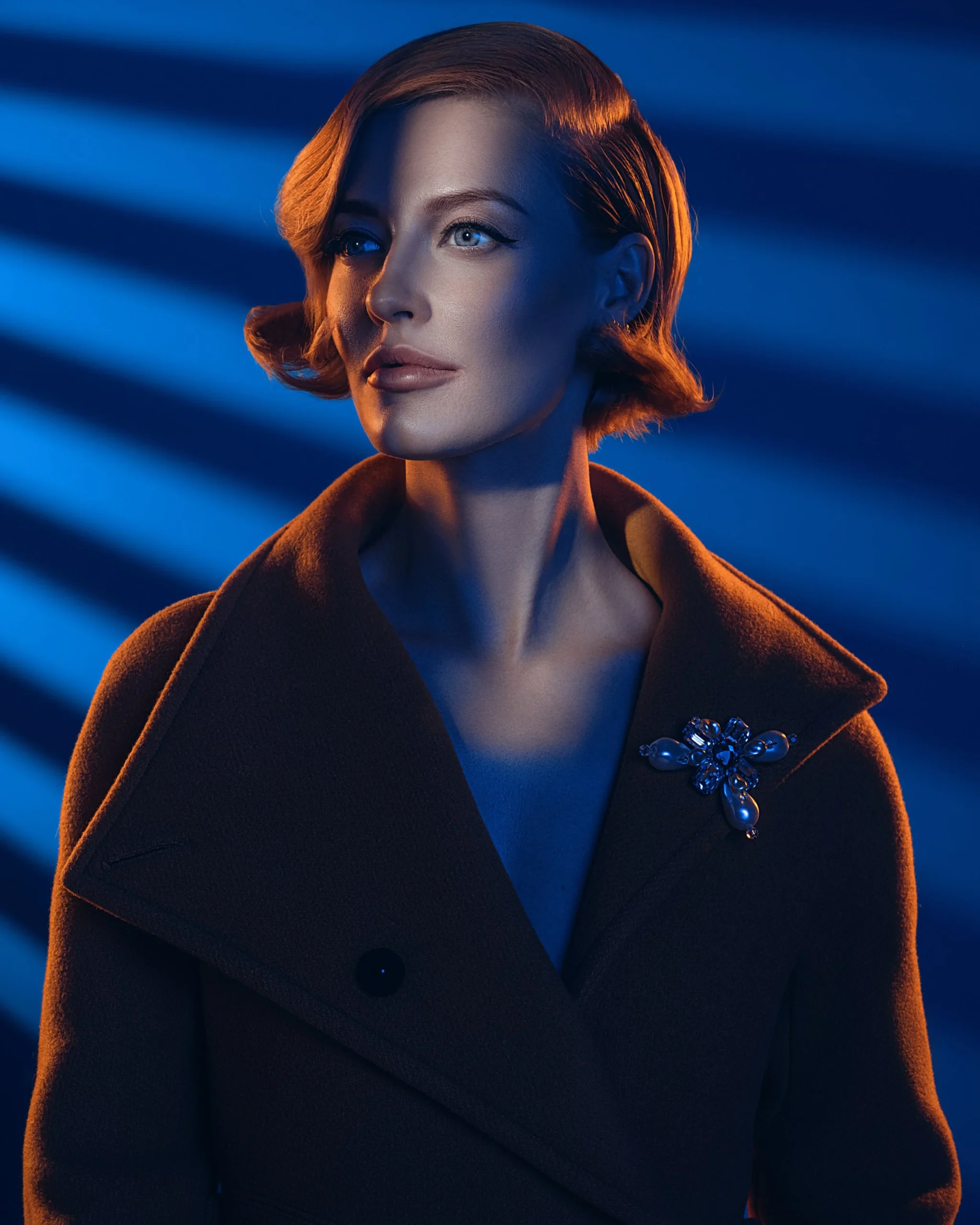 Portrait of a woman in blue light wearing a vintage brooch