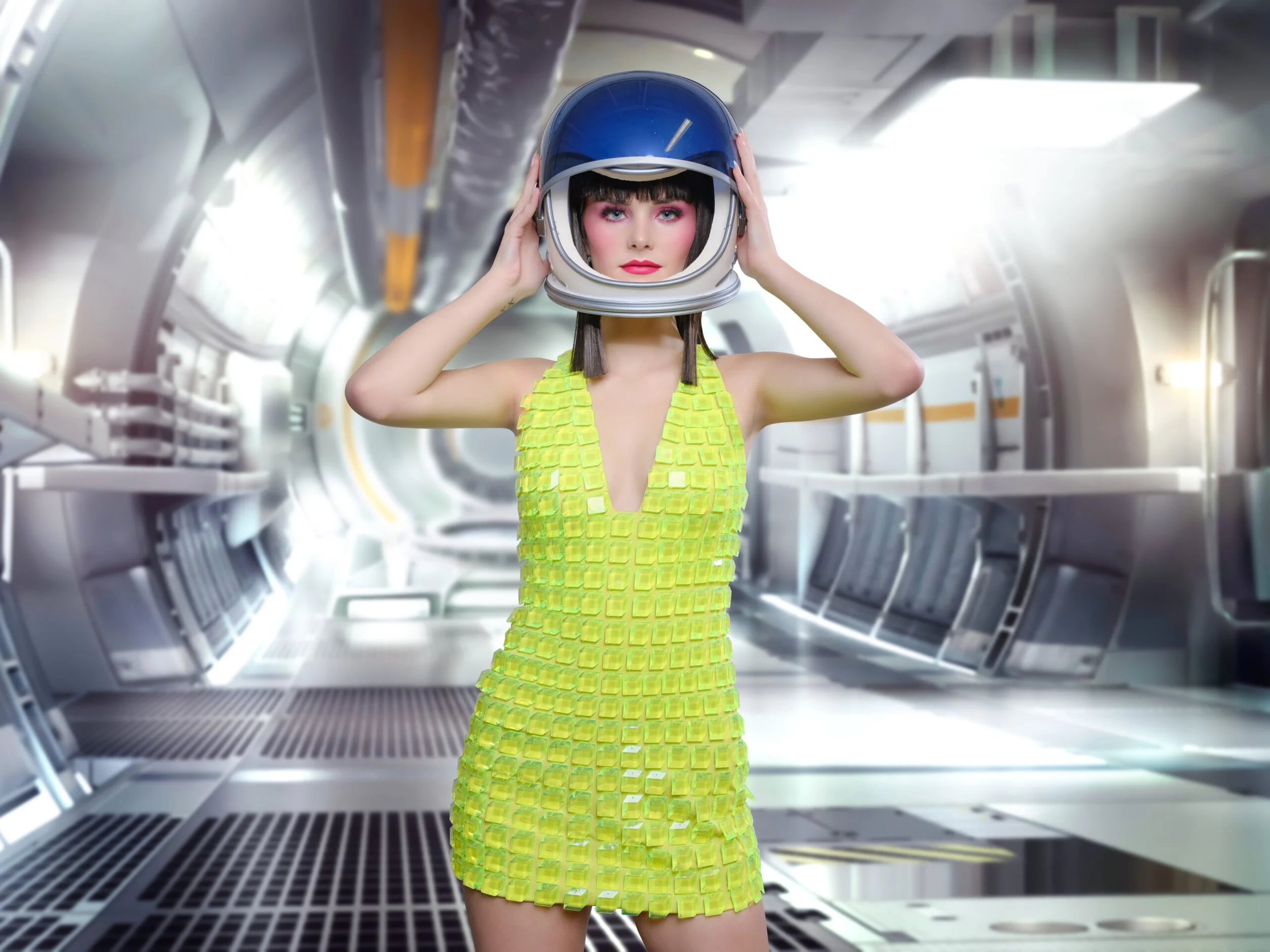 Retro futurist fashion portrait of a model in a yellow dress and helmet aboard a spacecraft set