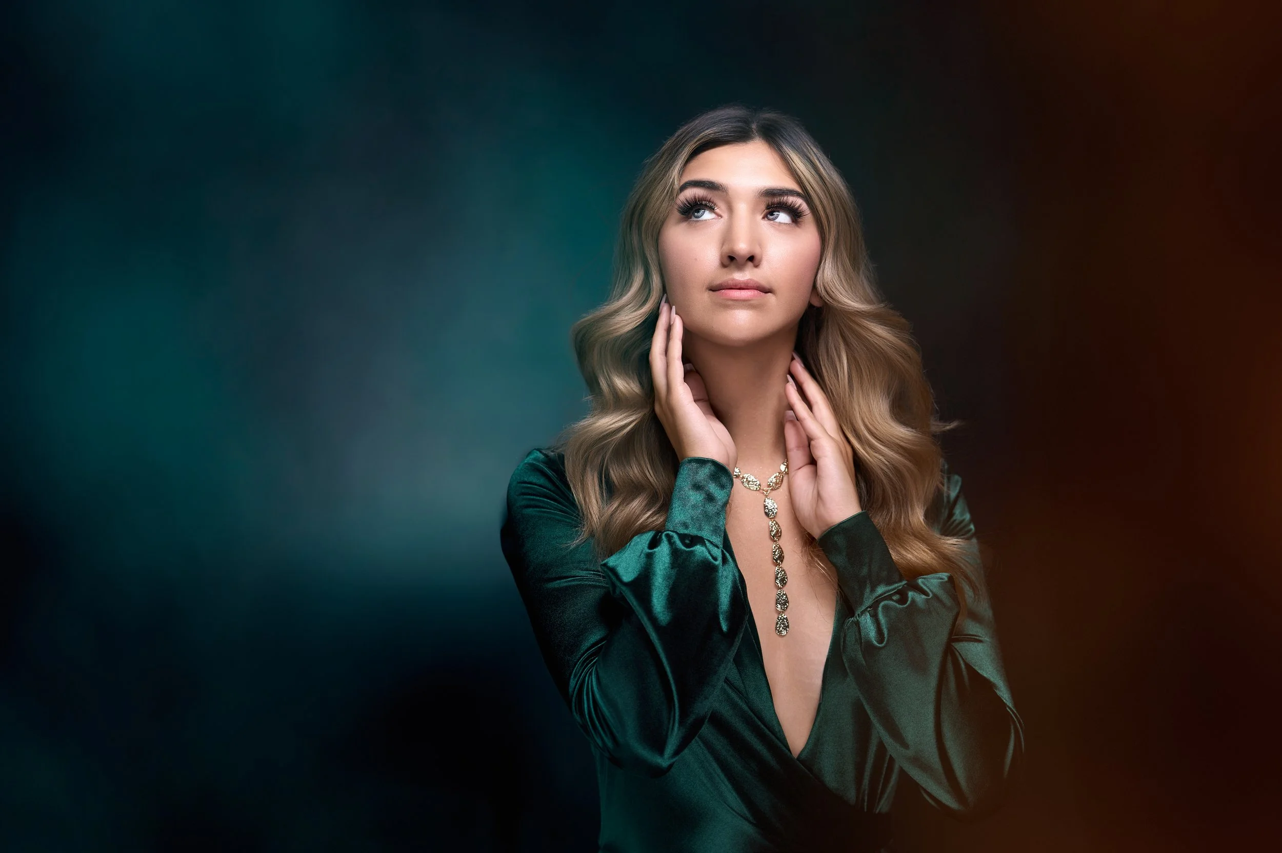 Warm editorial brand portrait of a woman against a teal and amber backdrop
