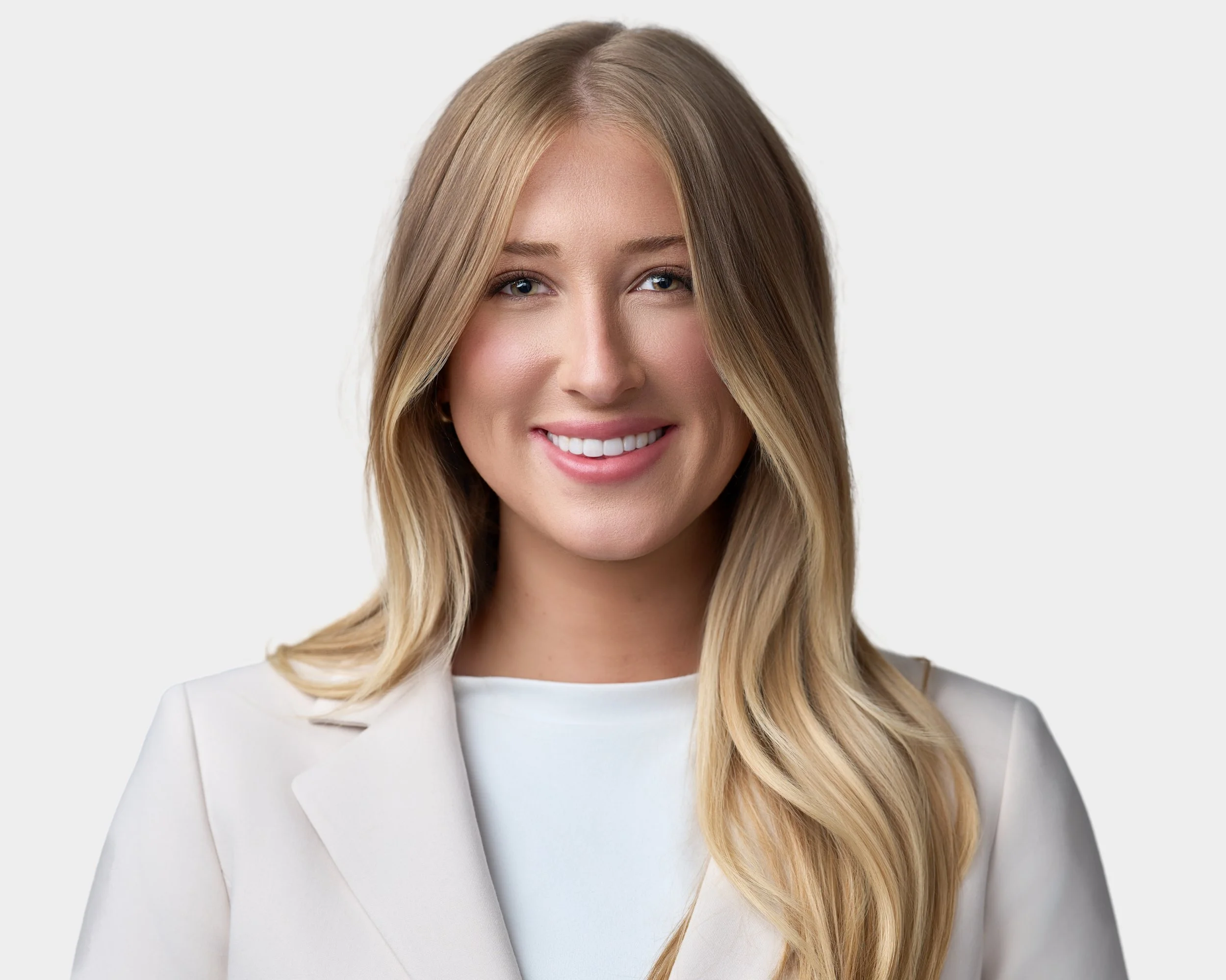 Smiling businesswoman in professional attire during a guided studio headshot session