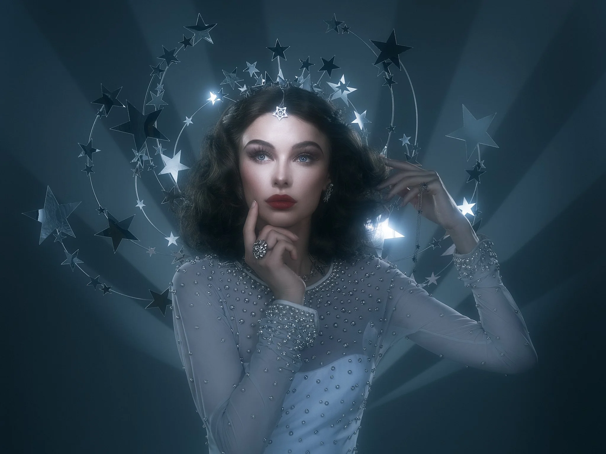Celestial themed portrait of a woman in a beaded gown surrounded by stars and light