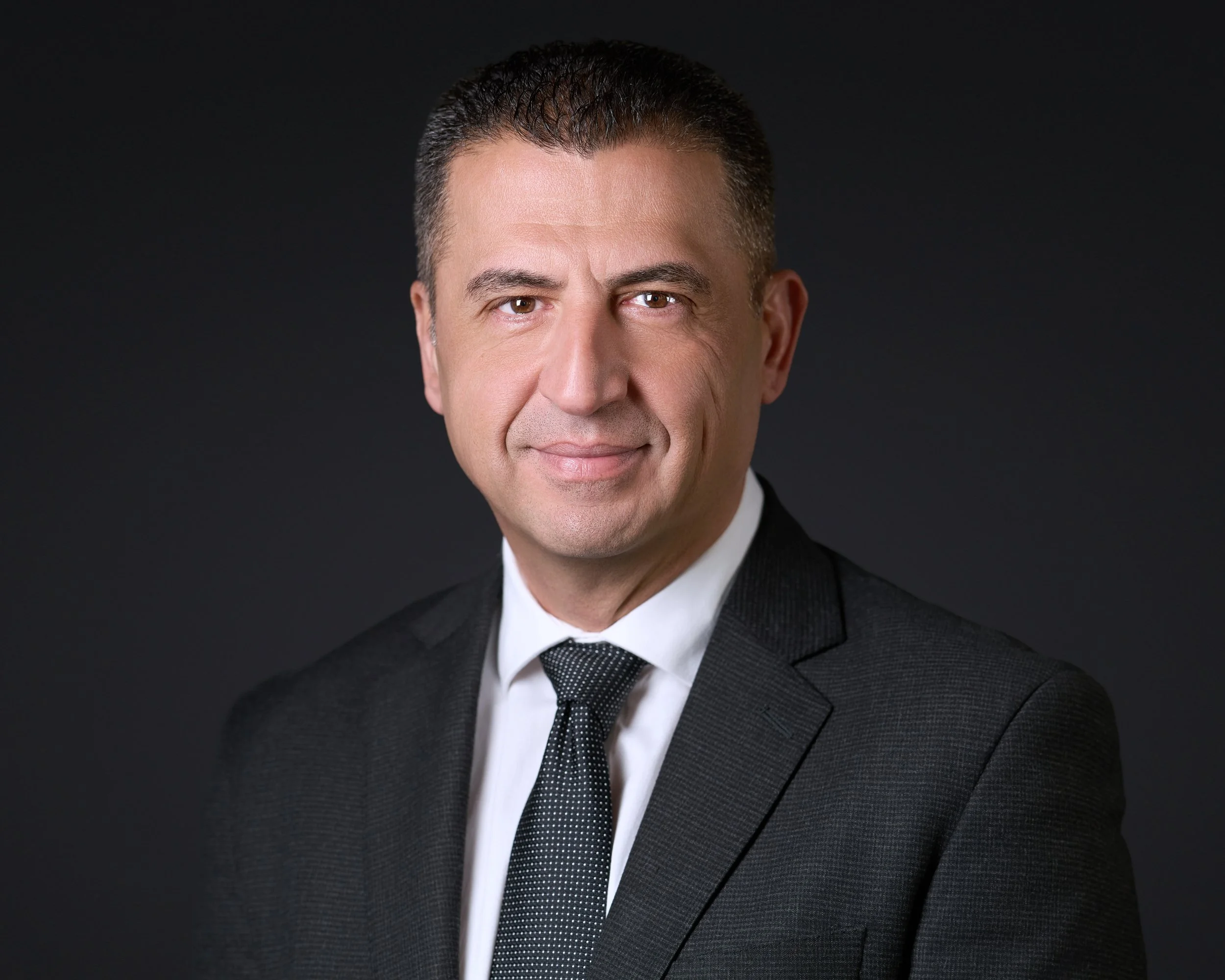 Executive headshot of a man in a suit lit with cinematic studio lighting
