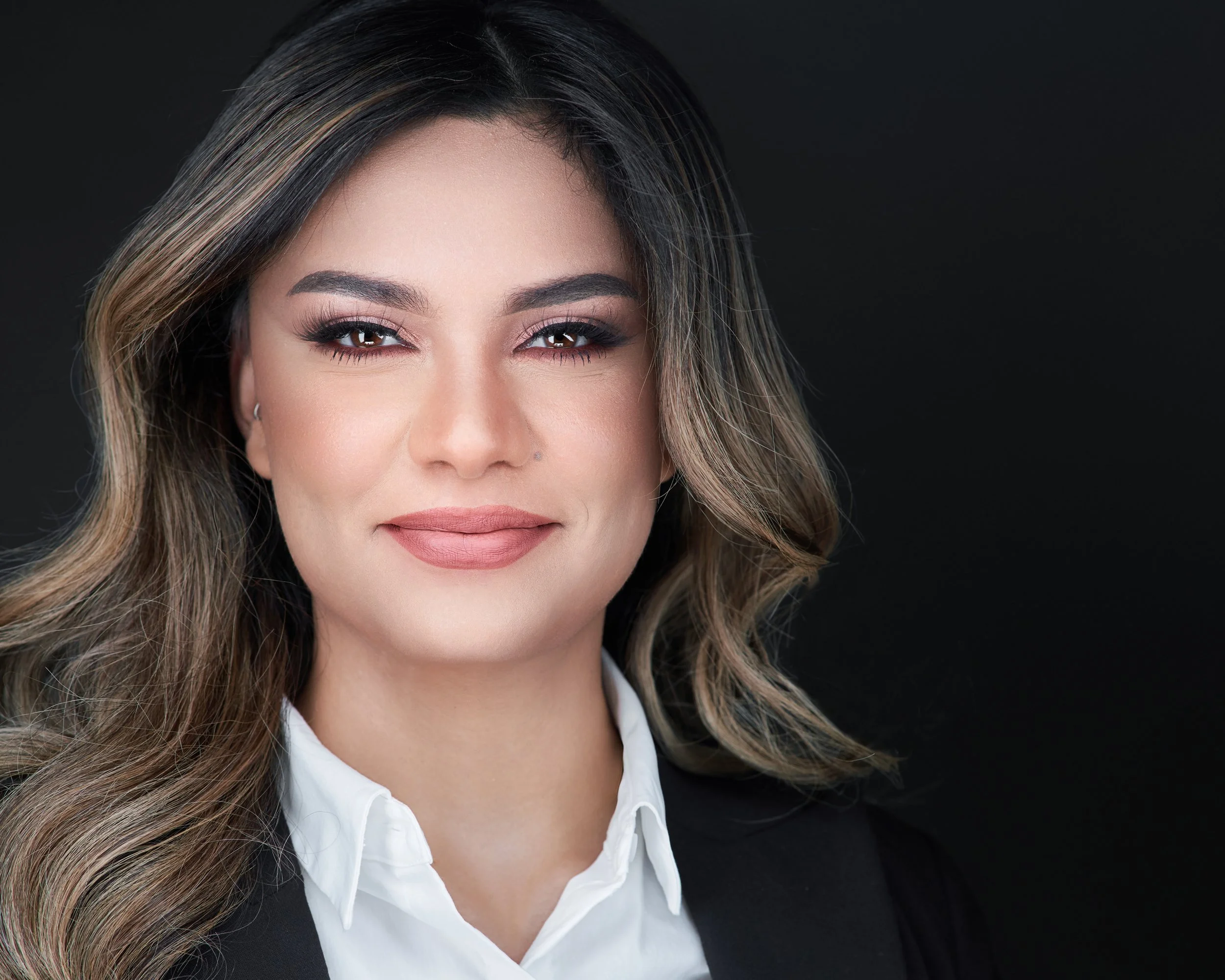 Business headshot of a professional woman against a neutral backdrop