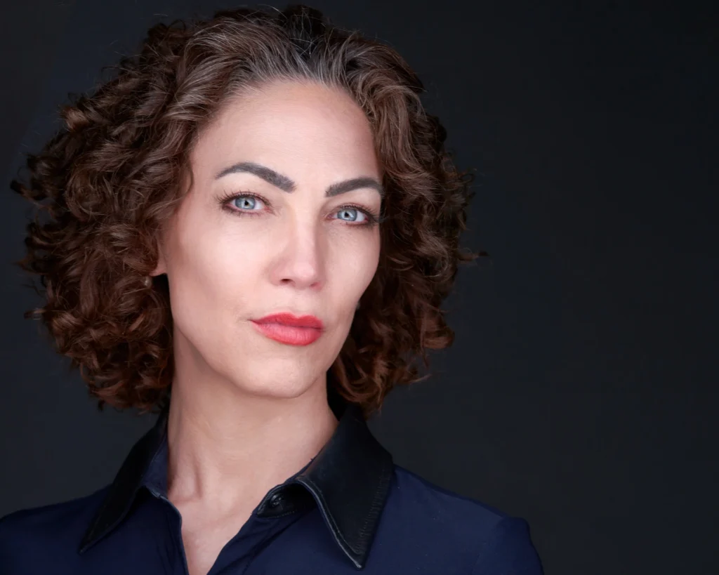 Corporate headshot of a woman in professional attire with warm studio lighting